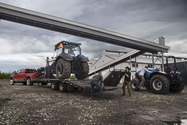 2023 Ford Super Duty hauling a tractor on a trailer