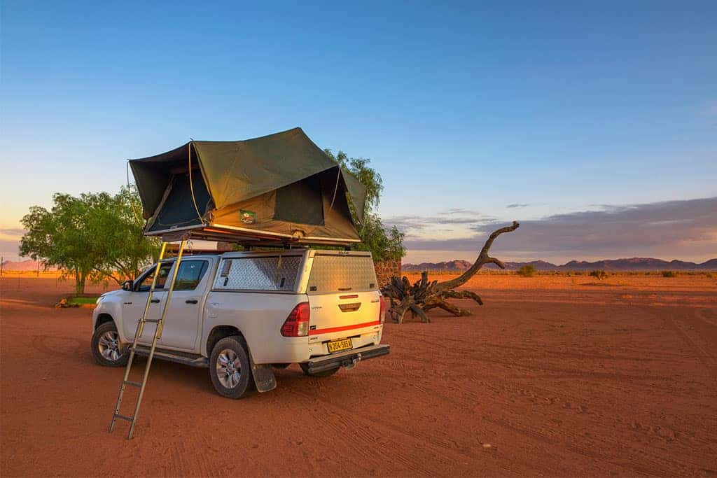 Tent located on the roof of a 4x4 pickup in a desert camp