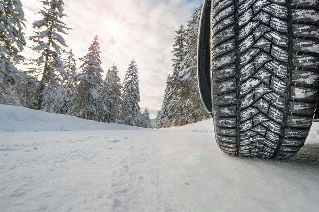 Winter tires on a car on a snowy road in the forest