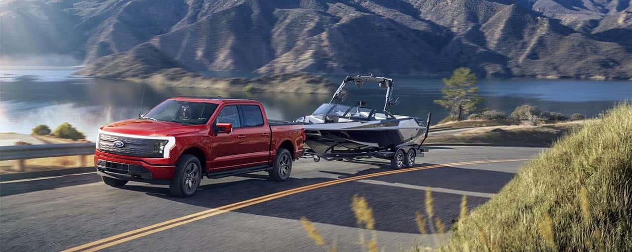 2023 Ford Lightning hauling a boat near a river