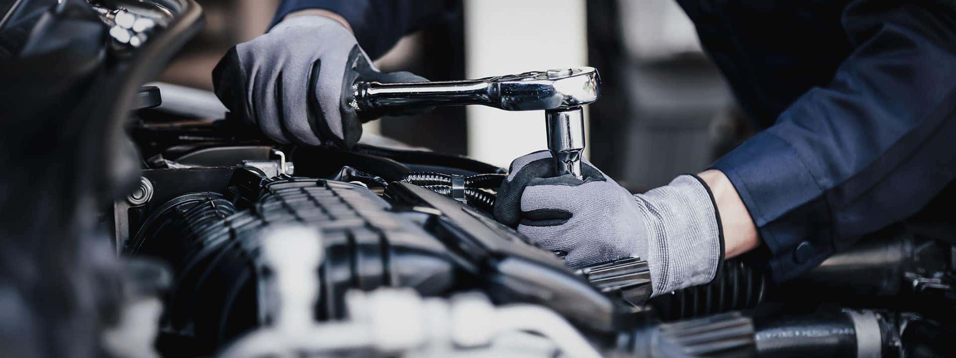 mechanic working on the engine of a car