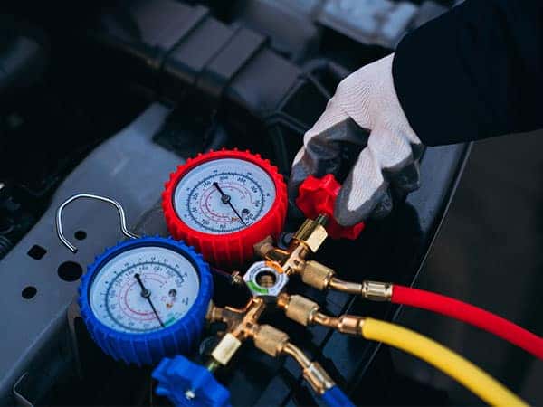 technician checking air conditioner in car