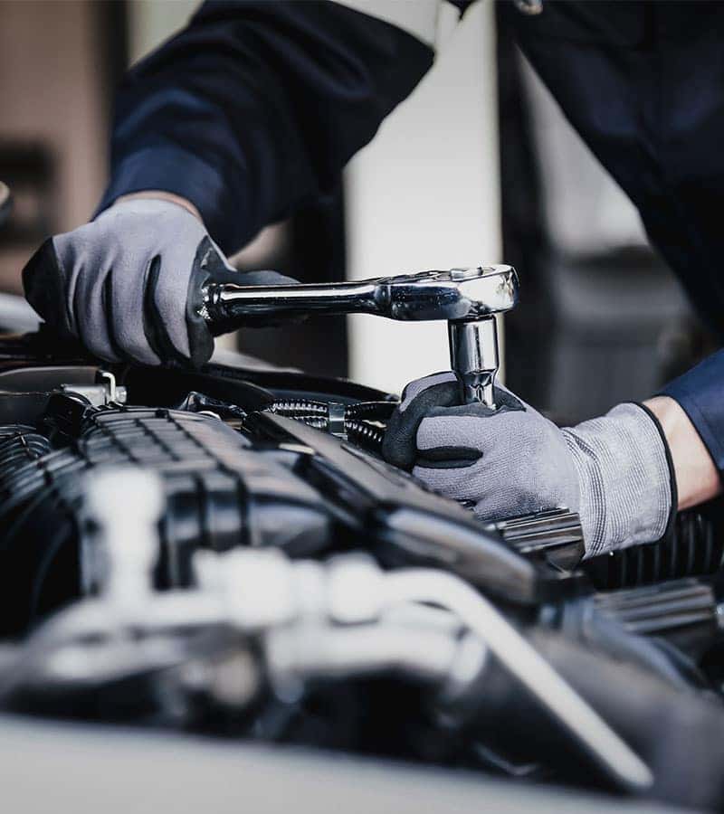 technician servicing the transmission of a car
