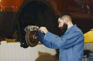 man fixing car brakes