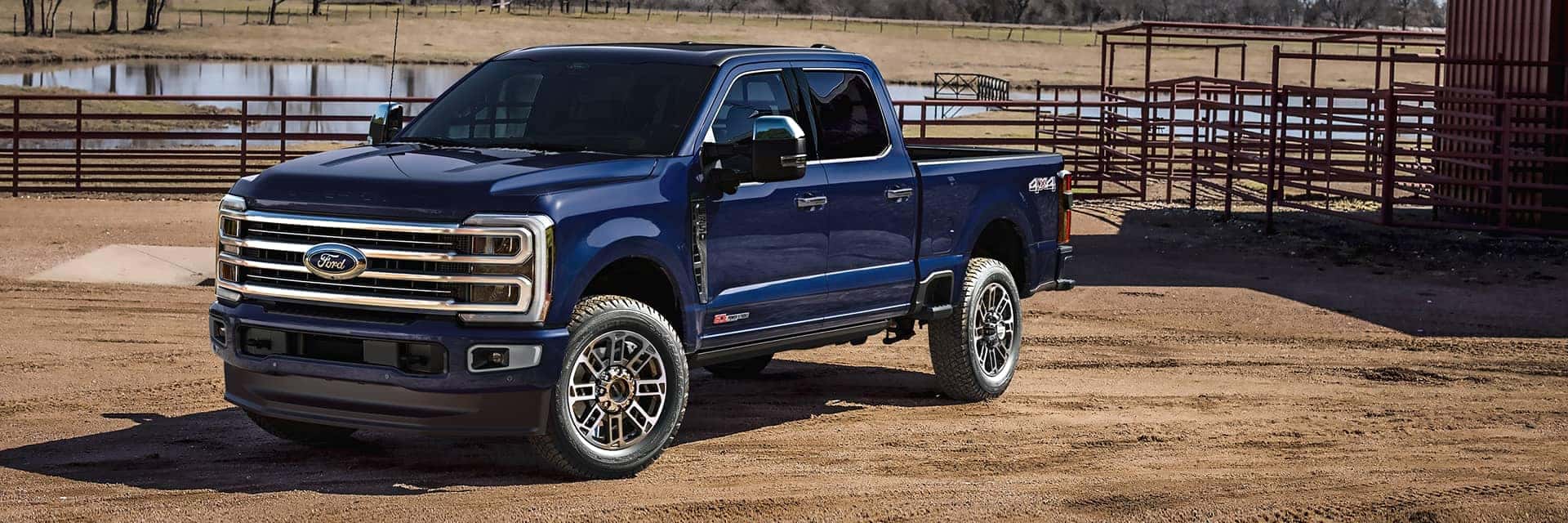 blue ford f350 parked in front of farm